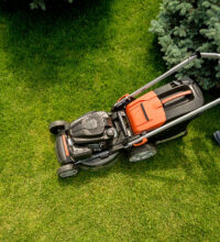 A professional lawnmower cutting grass, creating a neatly trimmed, lush green lawn in Lea Valley.